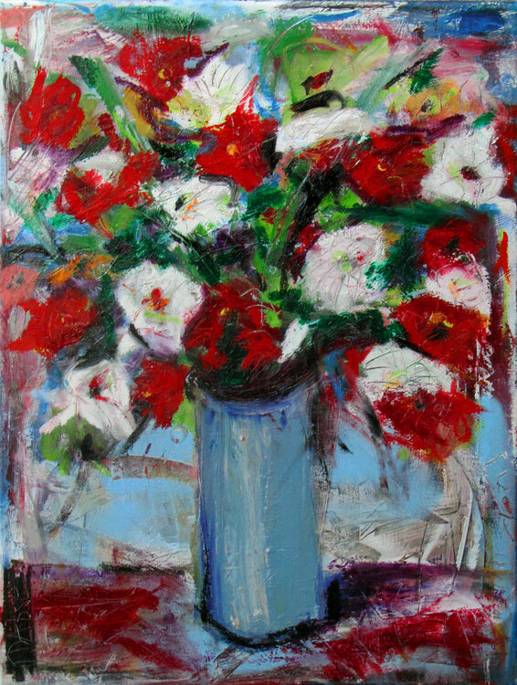 Red and white flowers in a tall blue vase David Abse